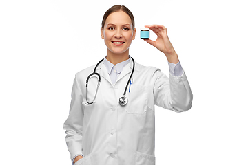 Image showing smiling female doctor holding jar of medicine