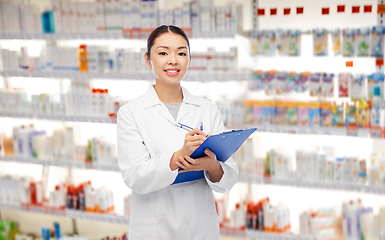 Image showing happy asian female pharmacist with clipboard