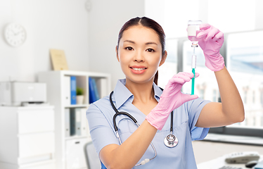 Image showing happy asian female nurse with syringe at hospital