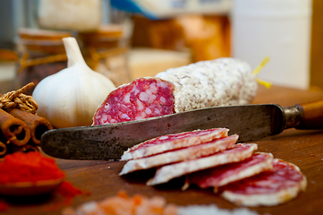 Image showing traditional Italian salame cured sausage sliced on a wood board