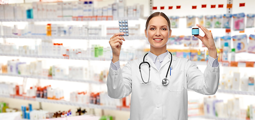 Image showing smiling female doctor holding medicine pills