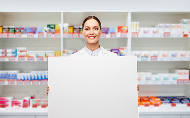 Image showing happy smiling female pharmacist with white board