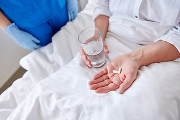 Image showing nurse giving medicine to senior woman at hospital