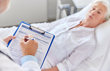 Image showing senior woman and doctor with clipboard at hospital