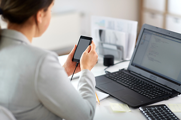 Image showing businesswoman with smartphone working at office