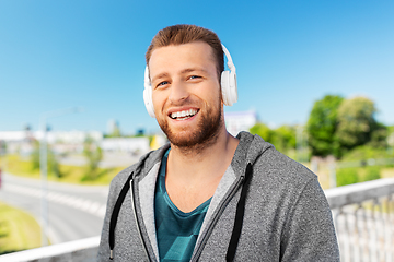 Image showing happy smiling man in headphones listening to music