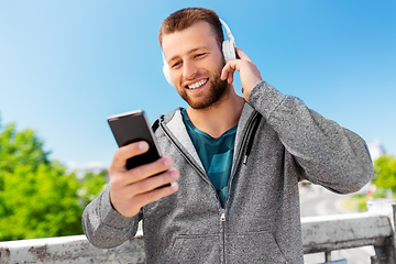 Image showing young man with headphones and smartphone