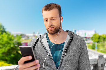 Image showing young man with earphones and smartphone