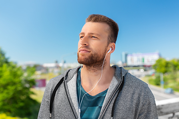 Image showing man in earphones listening to music outdoors