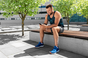 Image showing young athlete man with earphones and smartphone