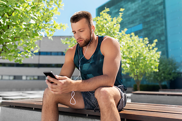 Image showing young athlete man with earphones and smartphone