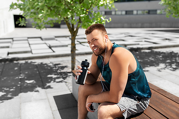Image showing sportsman with earphones and bottle in city