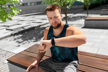 Image showing man with smart watch sitting on bench