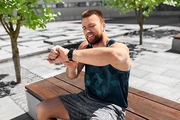 Image showing man with smart watch sitting on bench