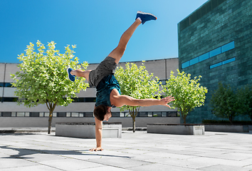 Image showing young man exercising and doing handstand outdoors