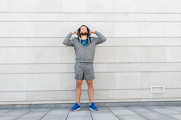 Image showing man in earphones listening to music outdoors