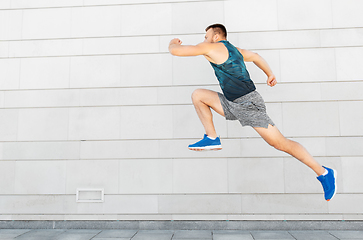 Image showing young man running or jumping outdoors