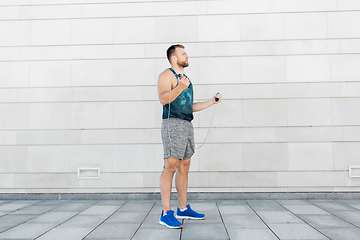 Image showing man exercising with jump-rope outdoors