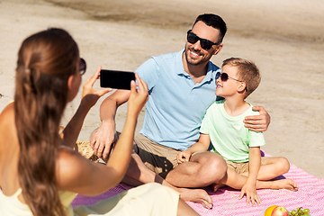 Image showing family with smartphone photographing on beach
