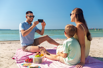 Image showing family with smartphone photographing on beach