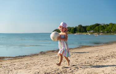 Image showing happy baby girl with ball running on summer beach