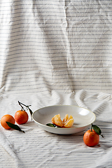 Image showing still life with mandarins on plate over drapery