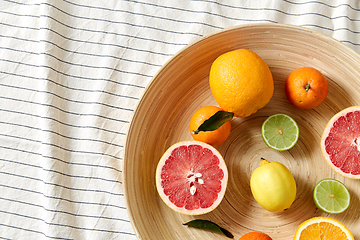 Image showing close up of citrus fruits on wooden plate