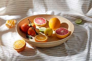 Image showing close up of citrus fruits on wooden plate