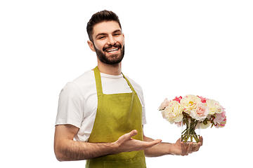 Image showing smiling male gardener with bunch of peony flowers