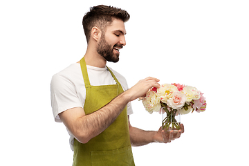 Image showing smiling male gardener with bunch of peony flowers