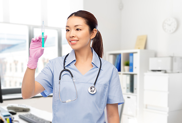 Image showing happy asian female nurse with syringe at hospital