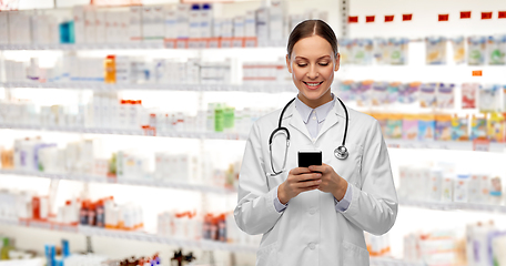 Image showing happy smiling female doctor with smartphone