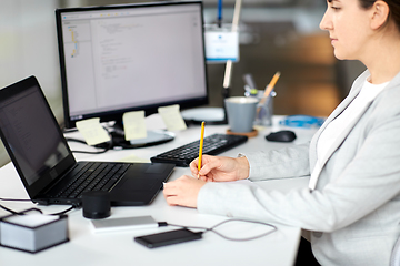 Image showing businesswoman with notebook and laptop at office