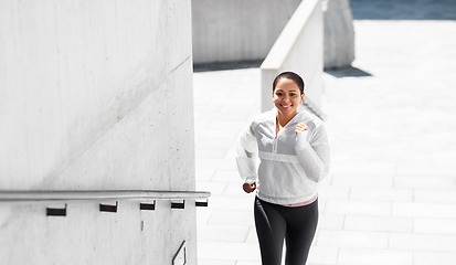 Image showing african american woman running upstairs outdoors