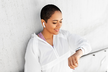 Image showing african woman with earphones and smart watch