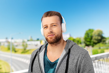 Image showing man in headphones listening to music outdoors