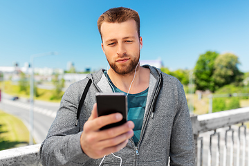 Image showing young man with earphones and smartphone