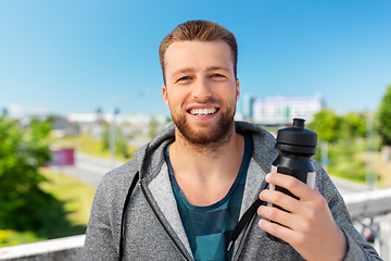 Image showing happy young man with sports bottle