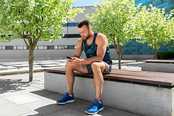 Image showing young athlete man with earphones and smartphone