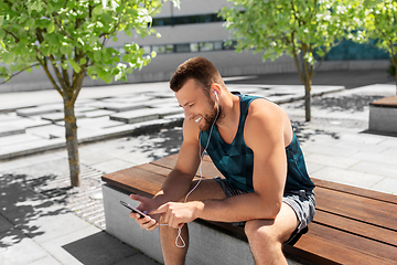 Image showing young athlete man with earphones and smartphone