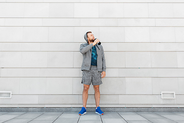 Image showing sportsman with bottle drinking water in city