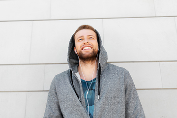 Image showing man in earphones listening to music outdoors