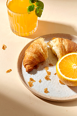 Image showing glass of orange juice and croissant on plate