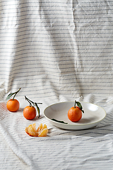 Image showing still life with mandarins on plate over drapery