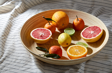 Image showing close up of citrus fruits on wooden plate