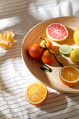 Image showing close up of citrus fruits on wooden plate