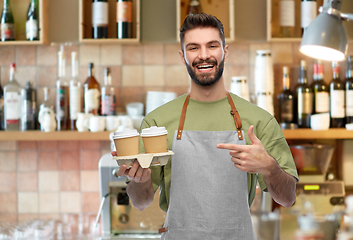 Image showing happy smiling barman in apron with takeaway coffee