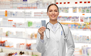 Image showing smiling female doctor holding medicine pills