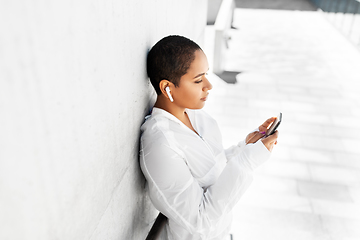 Image showing african american woman with earphones and phone