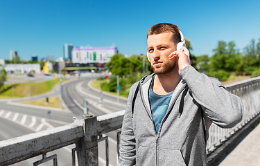 Image showing man in headphones listening to music outdoors